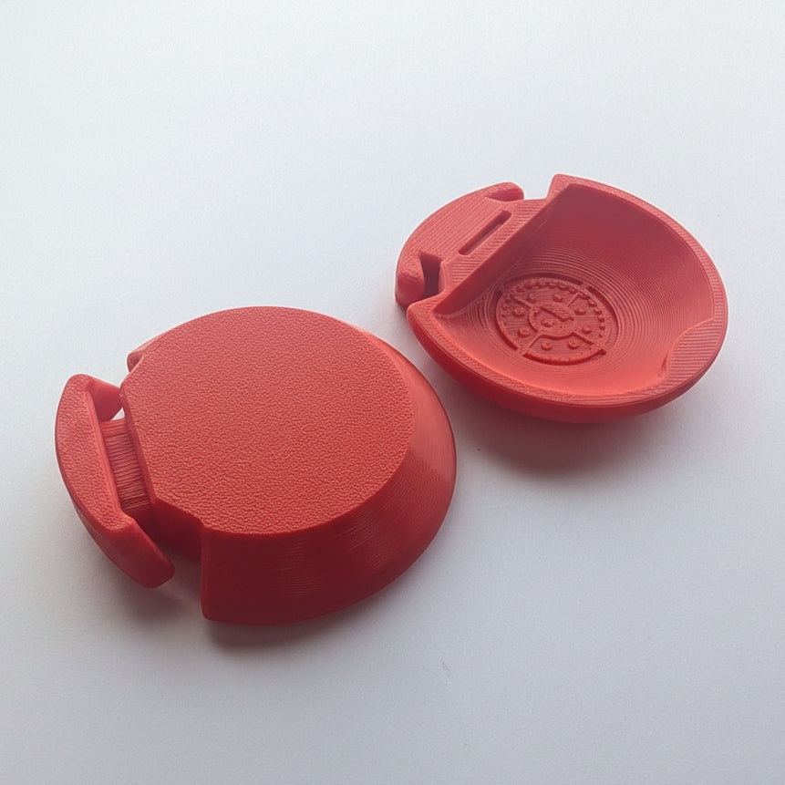 A red castanet, one showing the textured outer surface and the other showing the inner molded pattern, on a white background.